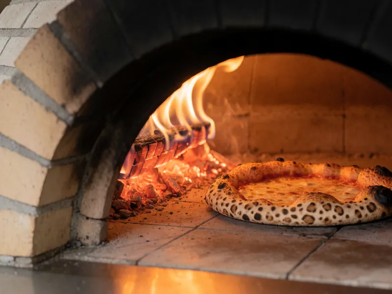 Turning a pizza in the brick oven at Woodside Pizza, Woodside NY